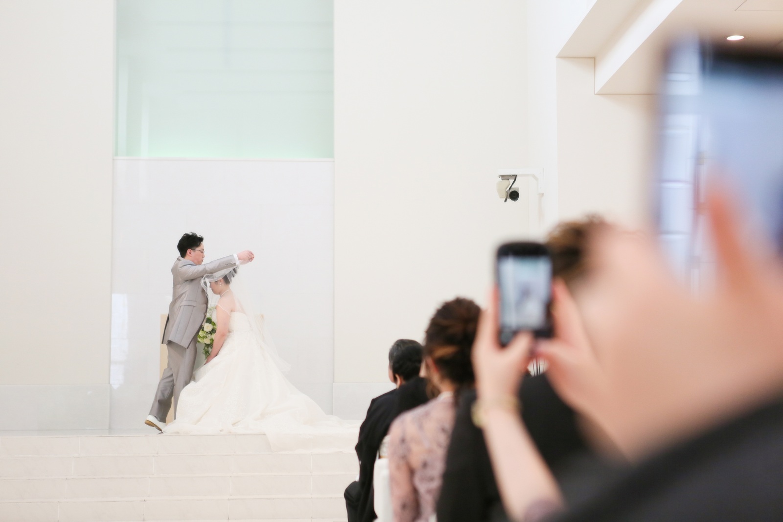 徳島市の結婚式場ブランアンジュのチャペル挙式の中でベールアップしている新郎