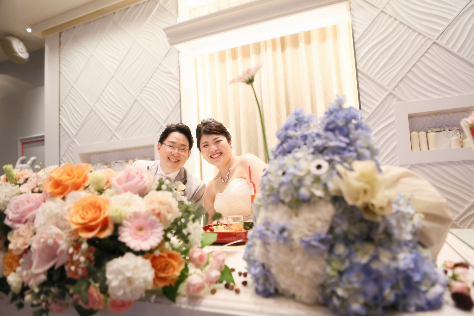 徳島市の結婚式場ブランアンジュの披露宴会場で笑顔の記念写真を撮る新郎新婦