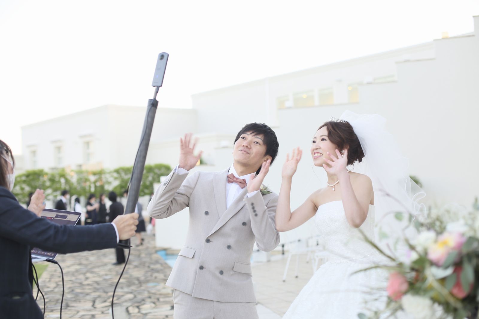 徳島県の結婚式場ブランアンジュでリモートでつながるゲストに手をふる新郎新婦